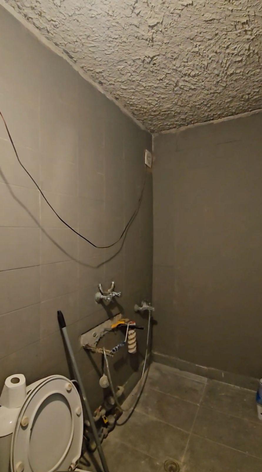 Стара баня с амортизирани плочки преди ремонт